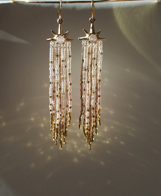 Star earrings with rose quartz, long beaded fringe, and gold accents reflecting the light