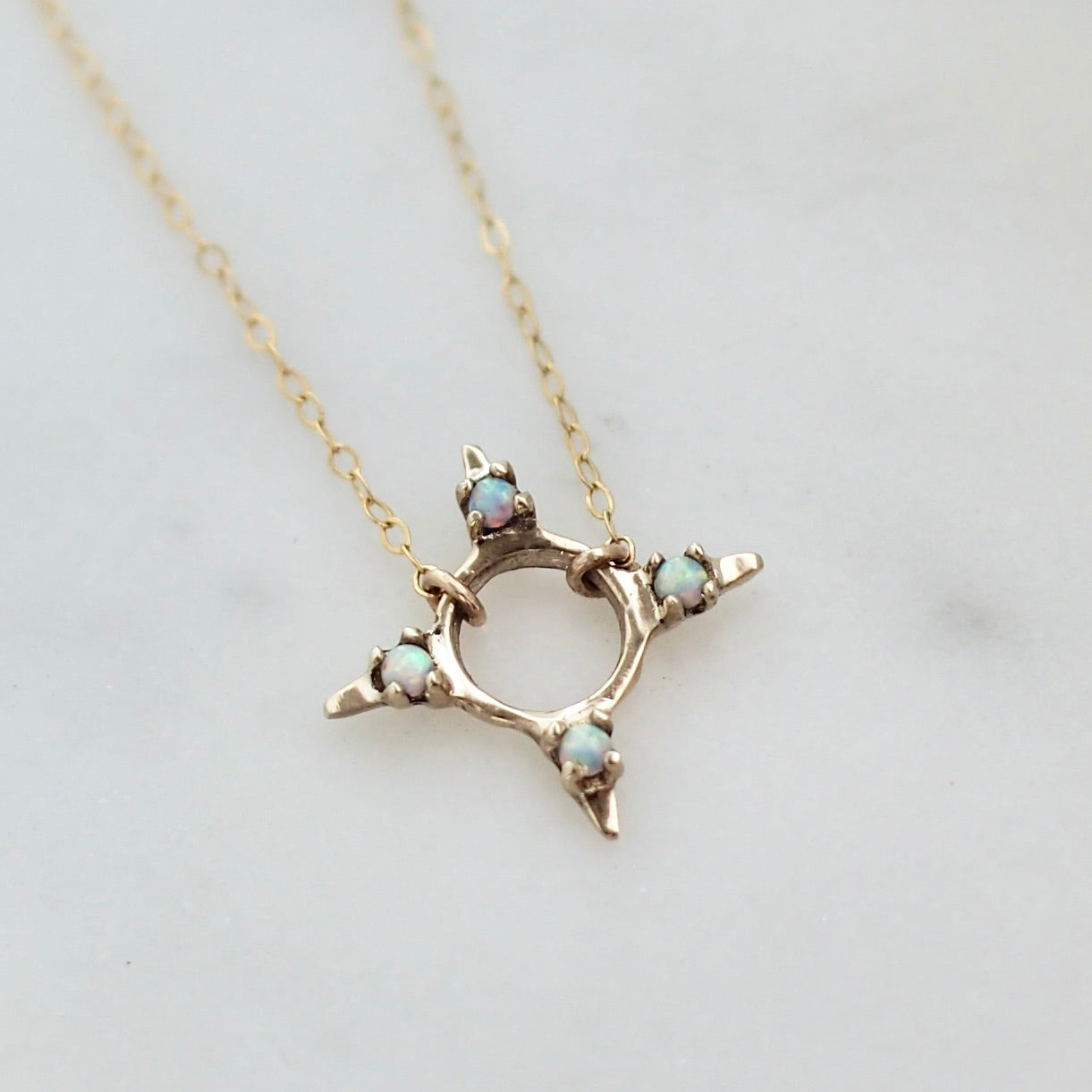 Four point star shaped Opal Eclipse Necklace by Iron Oxide designs made with 2mm lab grown opals set in bronze.