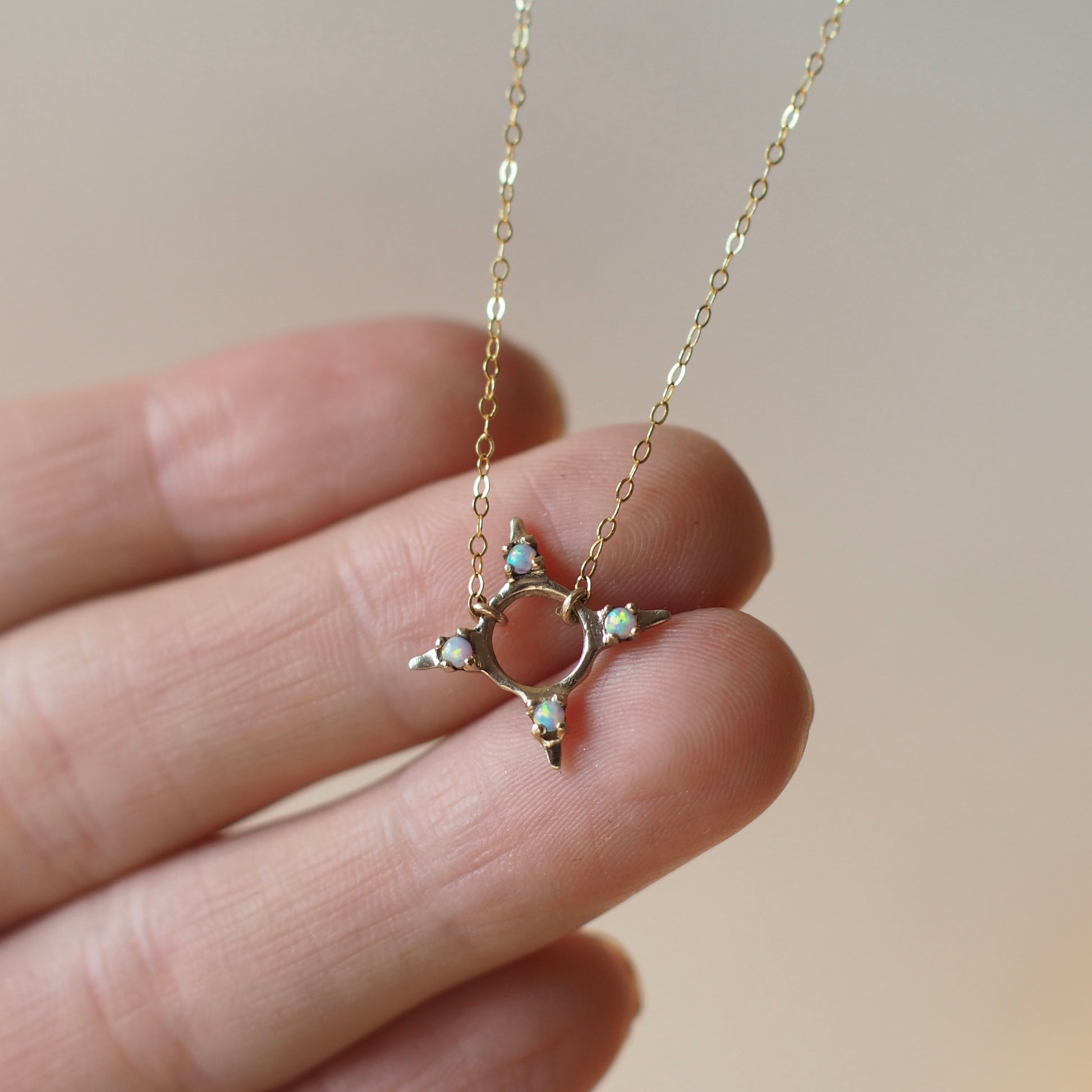 Four point star shaped Opal Eclipse Necklace by Iron Oxide designs made with 2mm lab grown opals set in bronze.