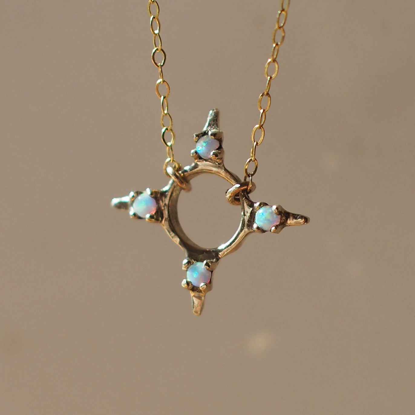 Four point star shaped Opal Eclipse Necklace by Iron Oxide designs made with 2mm lab grown opals set in bronze.