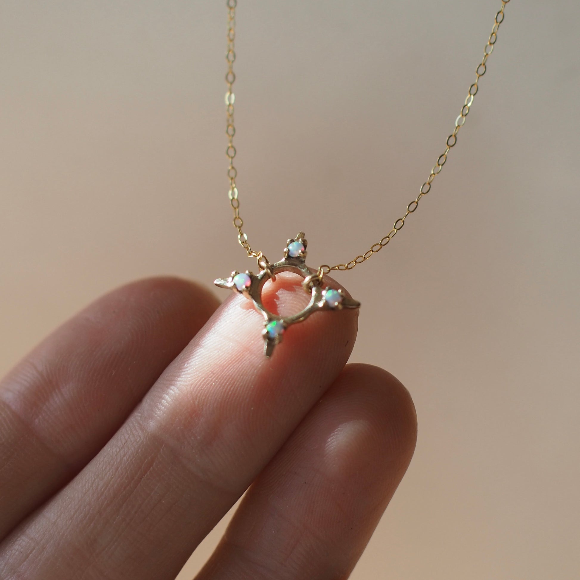 Four point star shaped Opal Eclipse Necklace by Iron Oxide designs made with 2mm lab grown opals set in bronze.