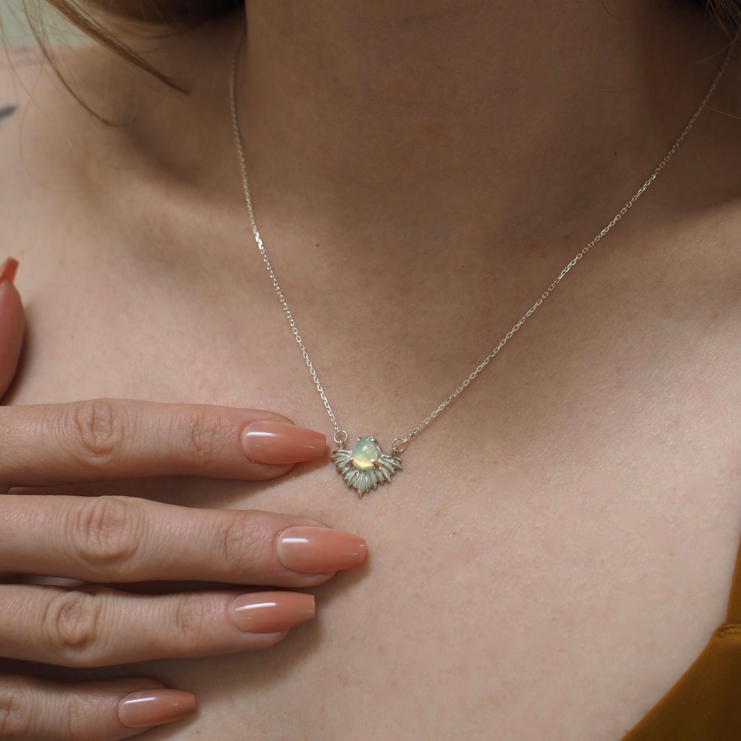 Cosmic opal necklace set in a sterling silver setting shown on a model for scale, handmade in the USA by Iron Oxide using sustainably sourced gemstones.