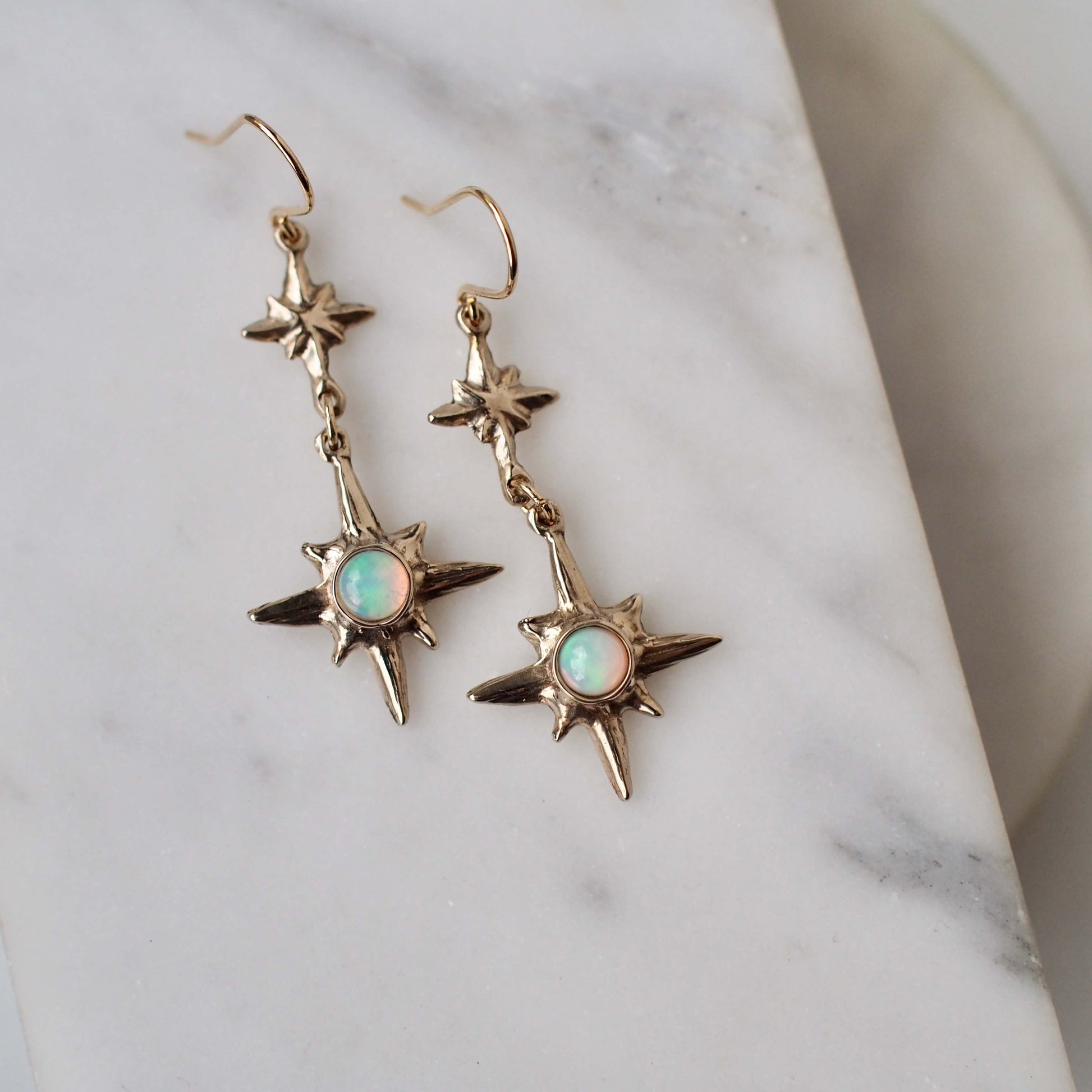 North Star Dangle earrings set with sustainably sourced natural opal, artisan made jewelry by Iron Oxide Designs.