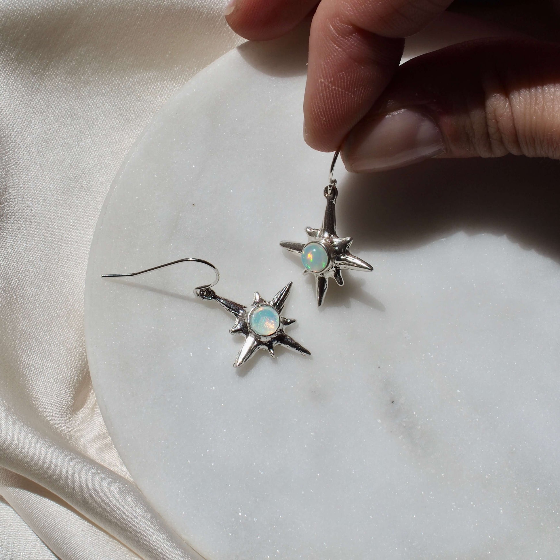North Star earrings set with sustainably sourced opal artisan made jewelry by Iron Oxide Designs