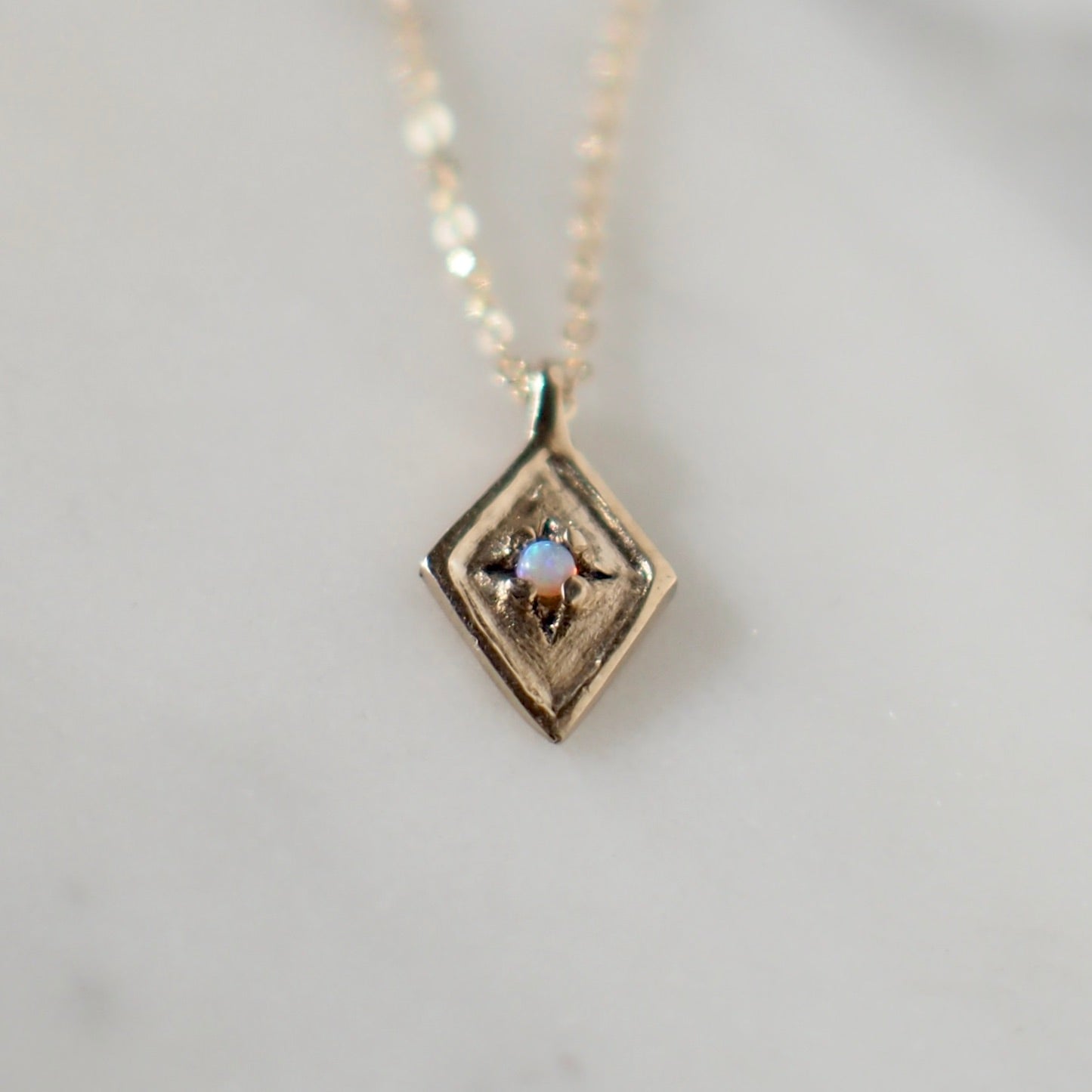 Dainty Diamond Shaped Medallion with  and 2mm Opal set within star engraved design handmade by Iron Oxide Designs