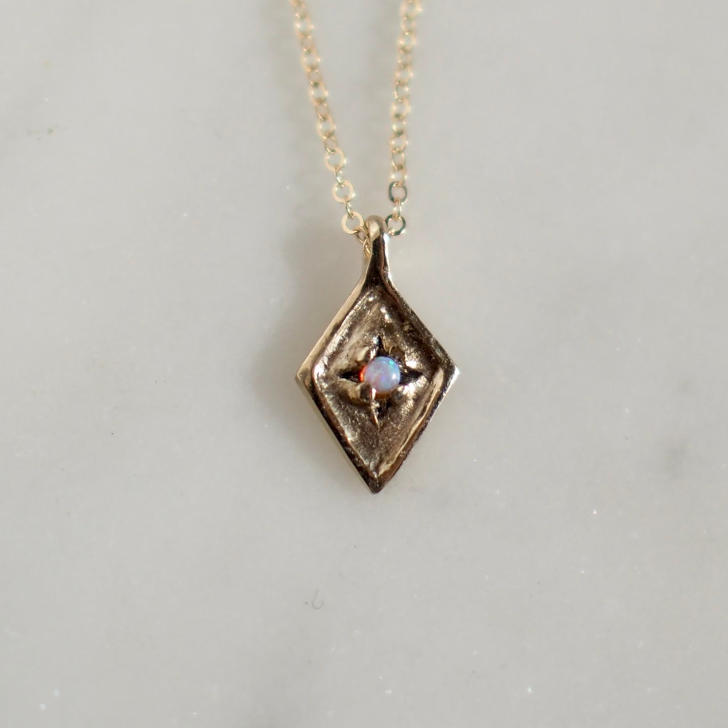 Dainty Diamond Shaped Medallion with  and 2mm Opal set within star engraved design handmade by Iron Oxide Designs