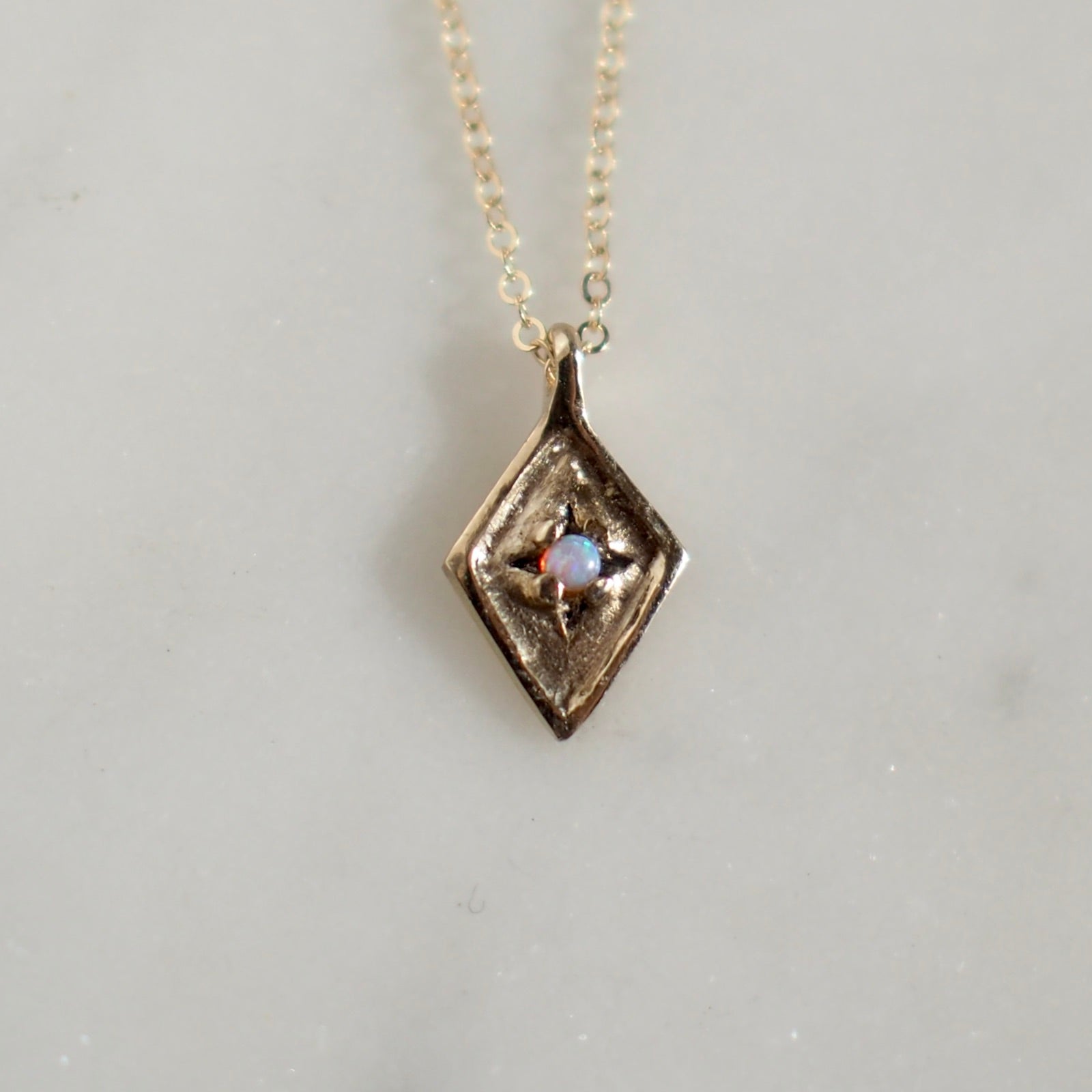 Dainty Diamond Shaped Medallion with  and 2mm Opal set within star engraved design handmade by Iron Oxide Designs