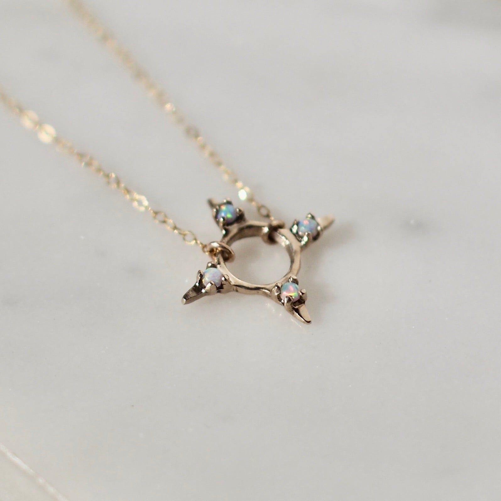 Four point star shaped Opal Eclipse Necklace by Iron Oxide designs made with 2mm lab grown opals set in bronze. 