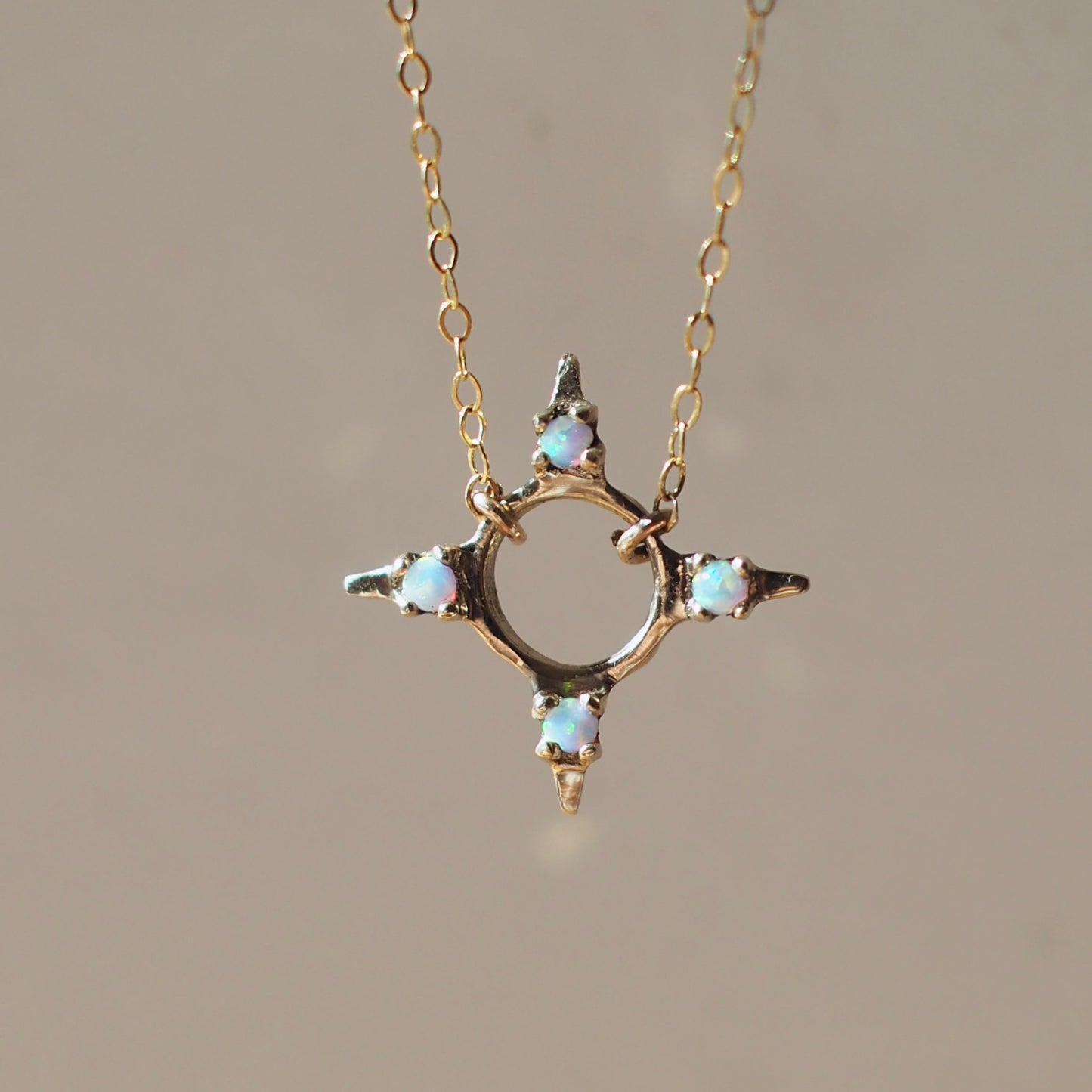 Four point star shaped Opal Eclipse Necklace by Iron Oxide designs made with 2mm lab grown opals set in bronze. 