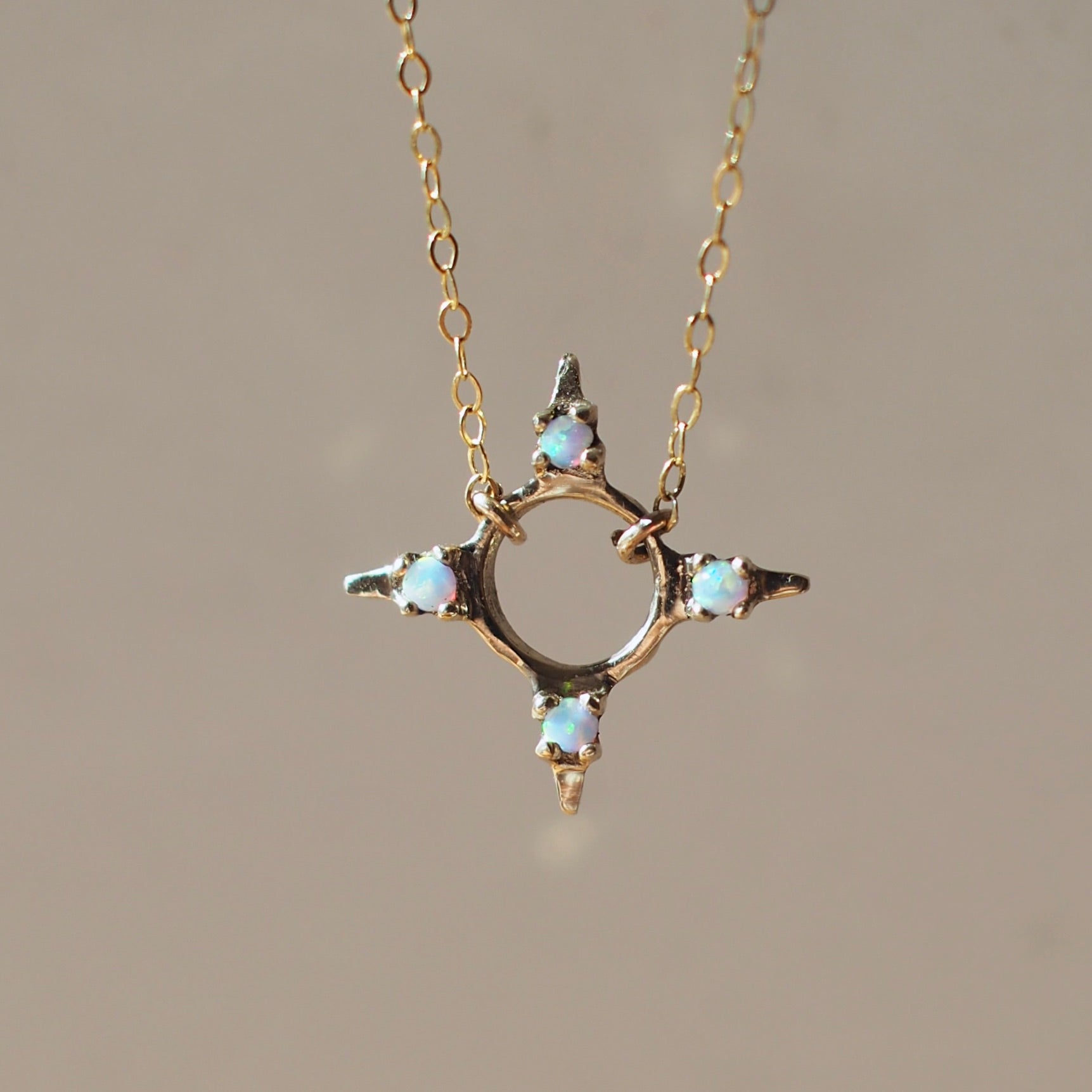 Four point star shaped Opal Eclipse Necklace by Iron Oxide designs made with 2mm lab grown opals set in bronze. 