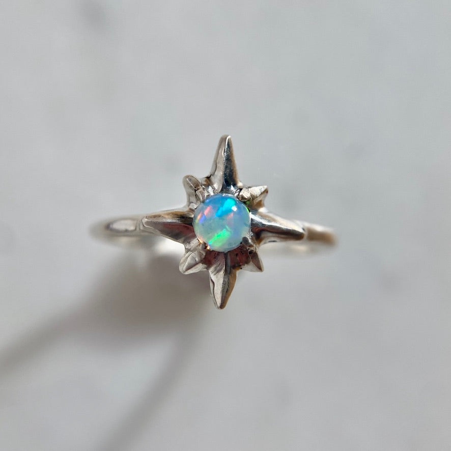 Silver north star ring set with a 5mm sustainably sourced opal, made by Iron Oxide Designs