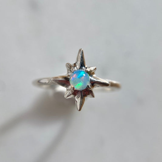 Silver north star ring set with a 5mm sustainably sourced opal, made by Iron Oxide Designs