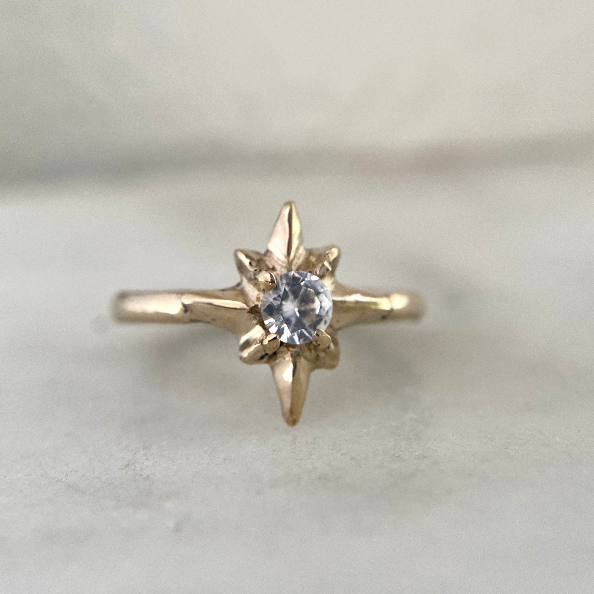 Polaris North Star Ring cast in gold tone bronze set with a clear Cubic Zirconia, by Iron Oxide Designs