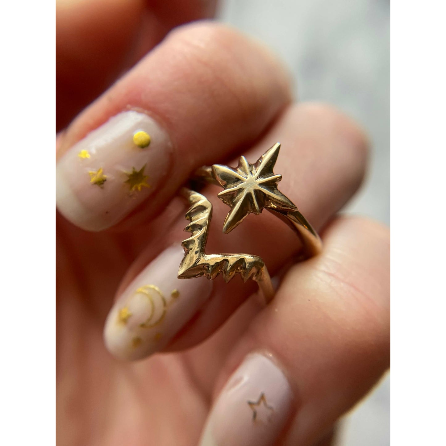 Celestial nesting star stacking ring set by Iron Oxide on a hand with a moon and star manicure