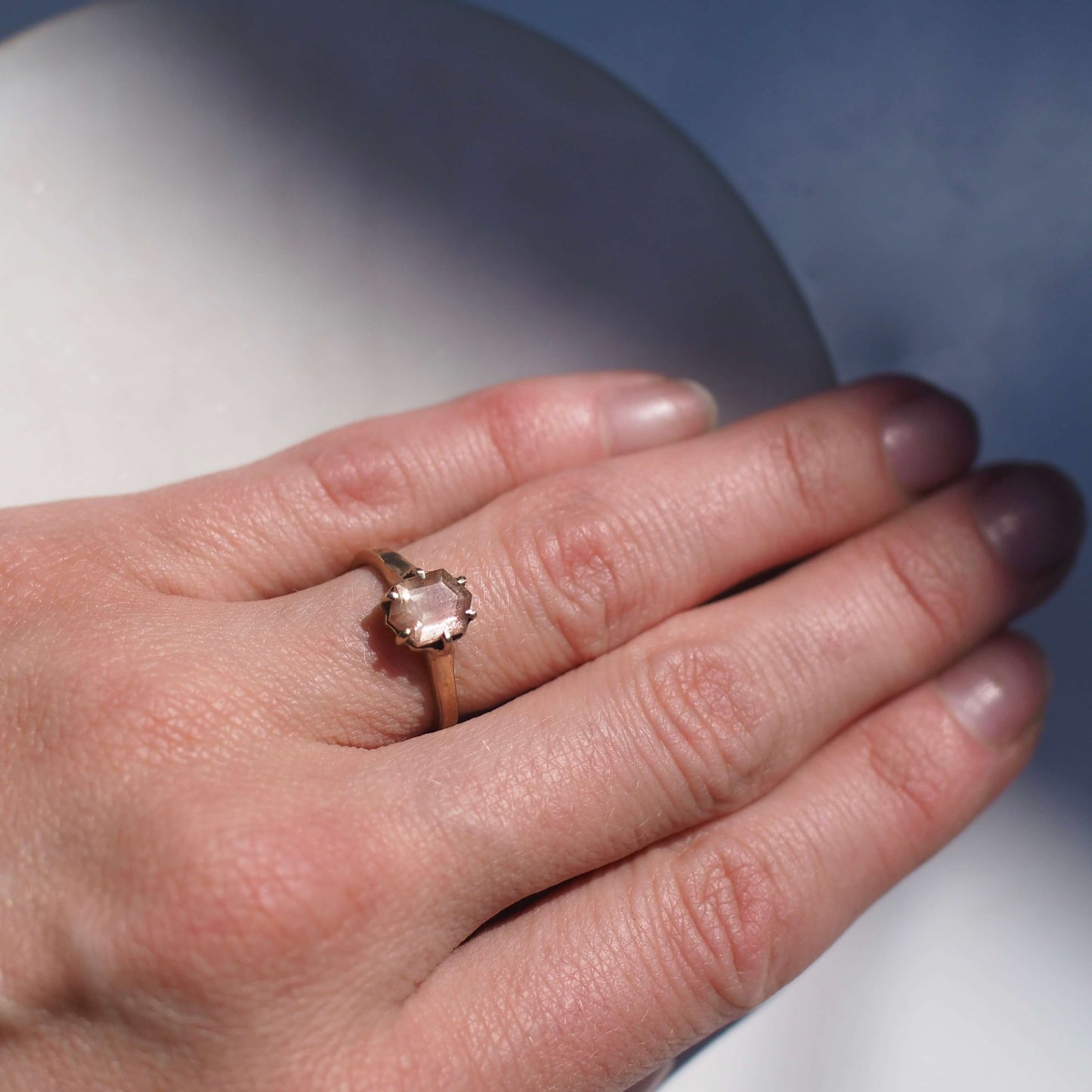 Shimmery Oregon Sunstone hexagonal ring gold tone bronze, handmade by Iron Oxide Designs, shown on a model for scale