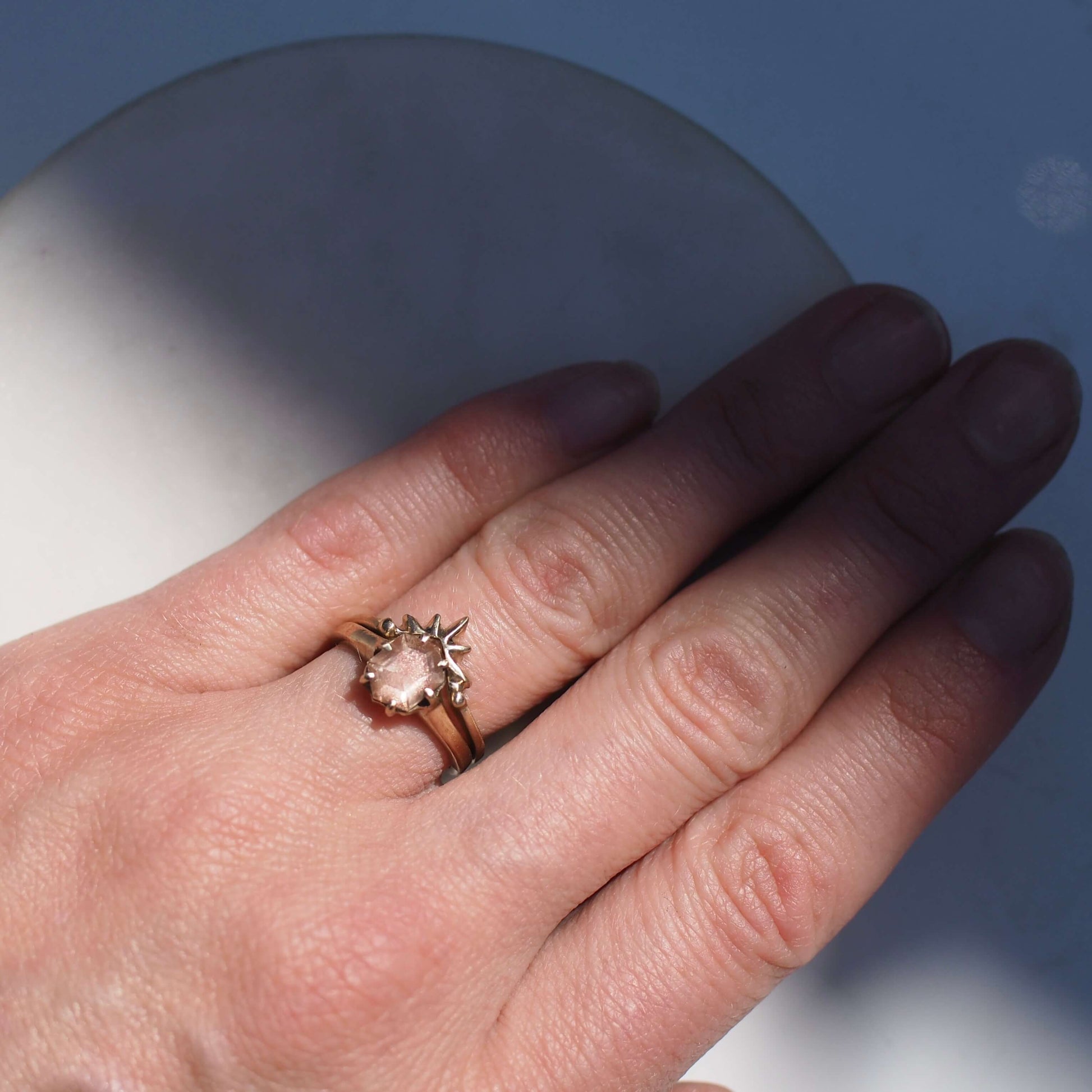 Sunstone Engagement Ring stacked with a Sunburst nesting band, sustainably mined jewelry handmade by Iron Oxide Designs. Shown on a model's hand for scale