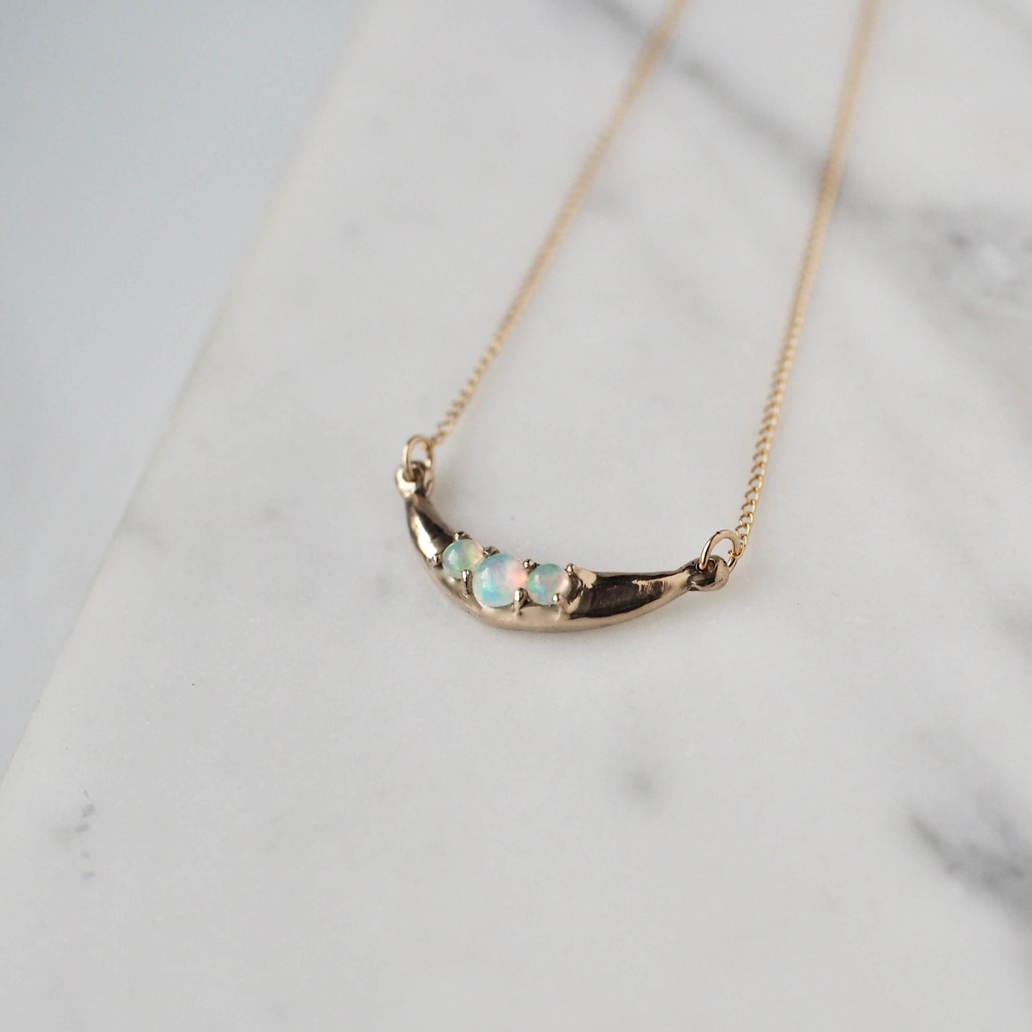 Crescent Moon necklace set with sustainably sourced opals cast in gold tone bronze by Iron Oxide
