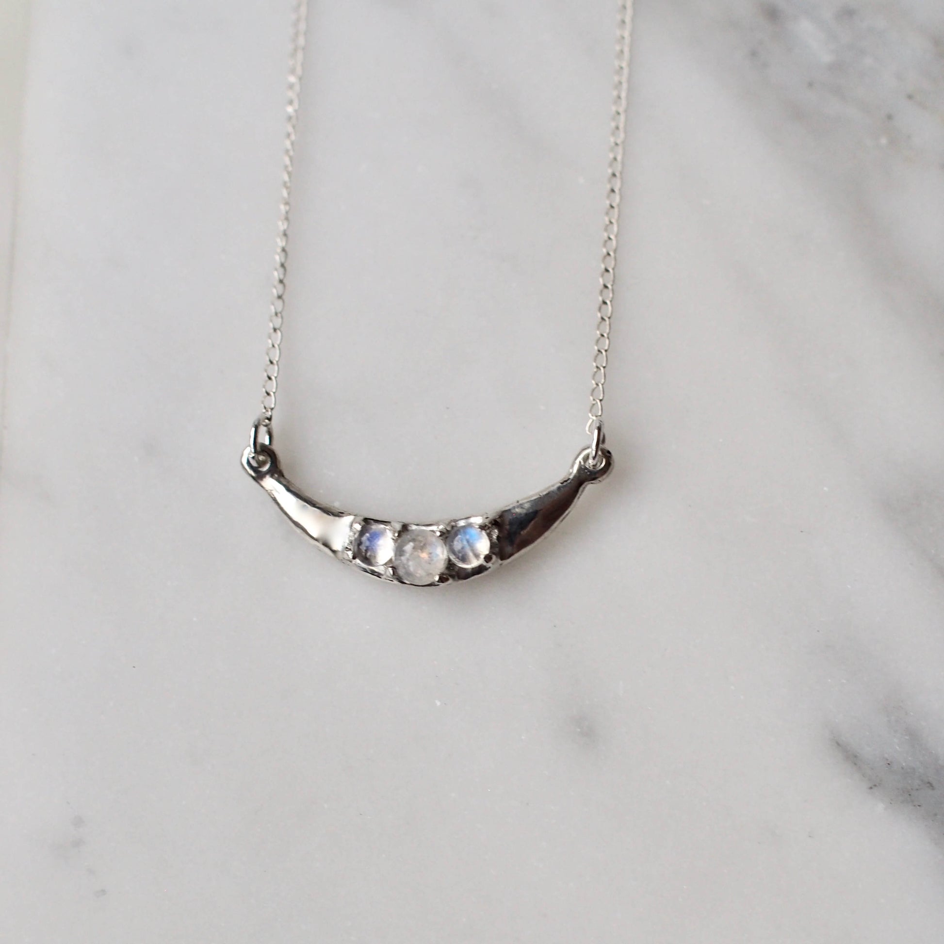 Crescent Moon necklace set with sustainably sourced moonstone, set in sterling silver. Made by hand in the USA by Iron Oxide