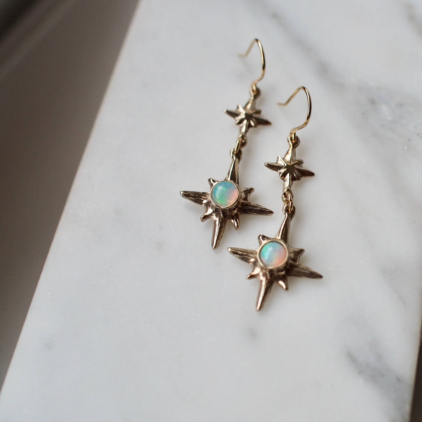 Polaris Star earrings set with sustainably sourced natural opal, artisan made jewelry by Iron Oxide Designs.