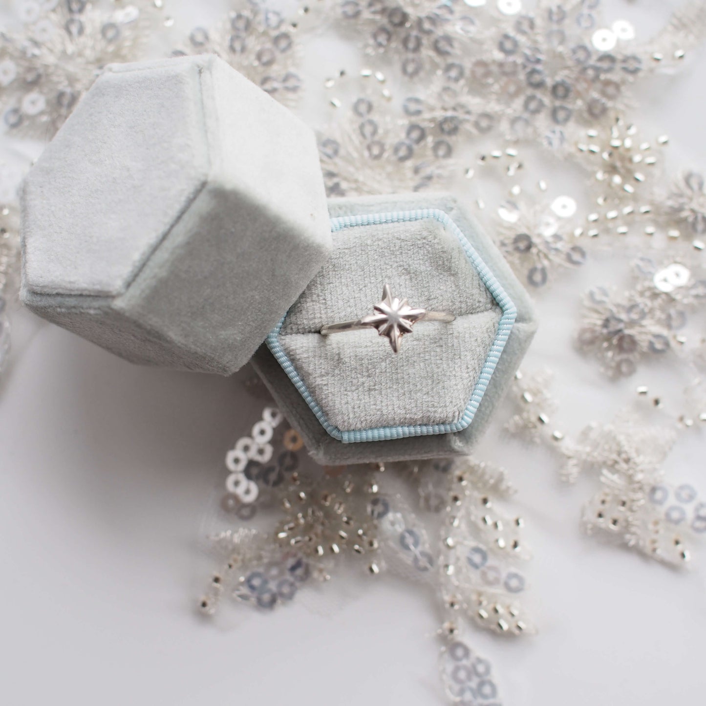 Celestial North Star Ring in sterling silver held in pale blue velvet ring box on top of bridal lace