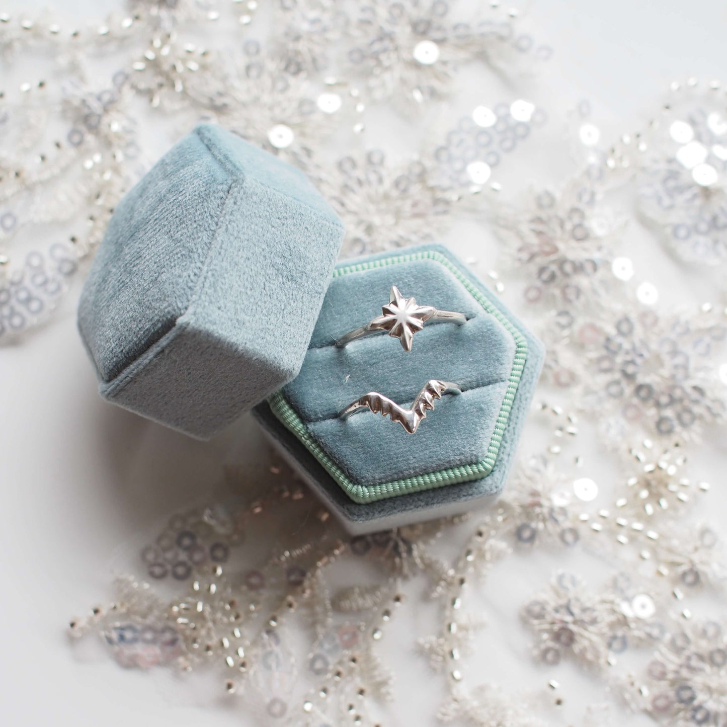 Celestial North Star Ring and nesting band in sterling silver held in eucalyptus blue velvet ring box on top of bridal lace