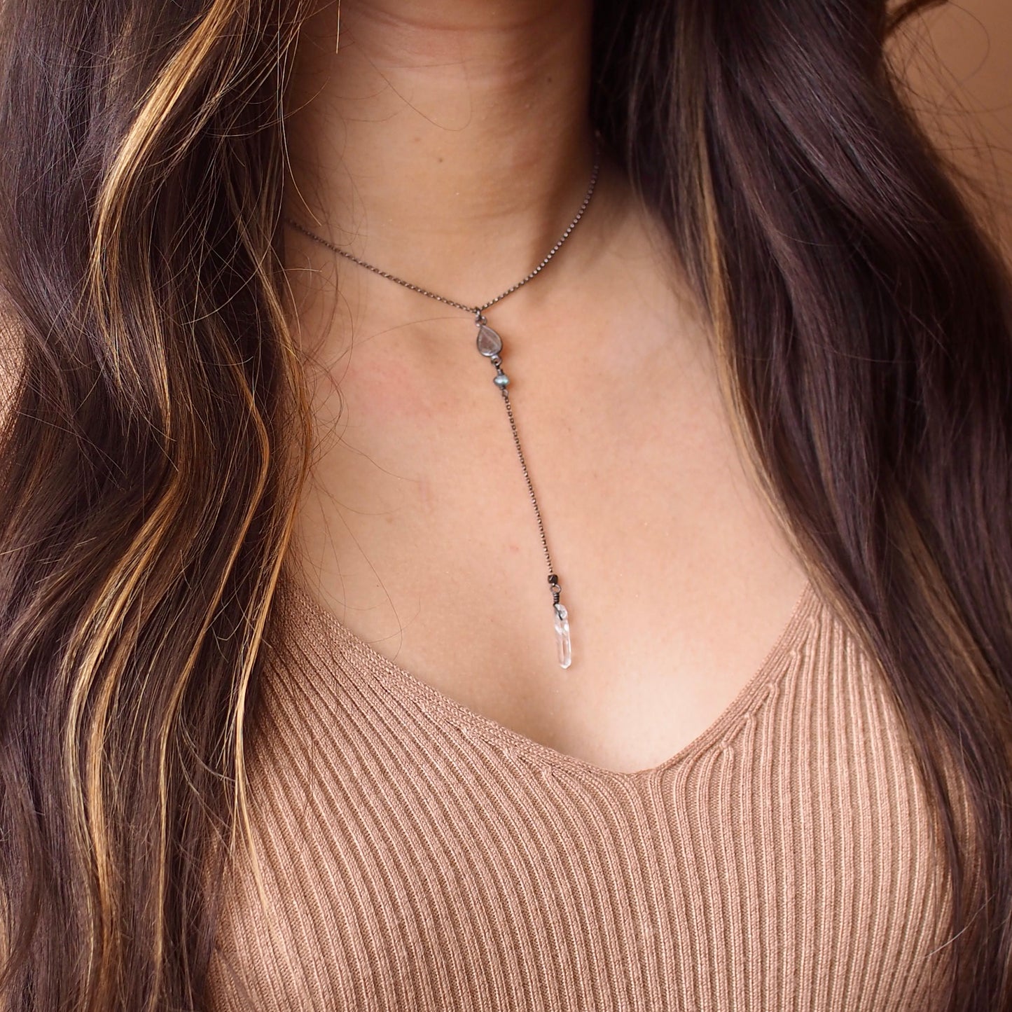 Labradorite lariat y necklace with crystal drop shown on a model for scale  Edit alt text