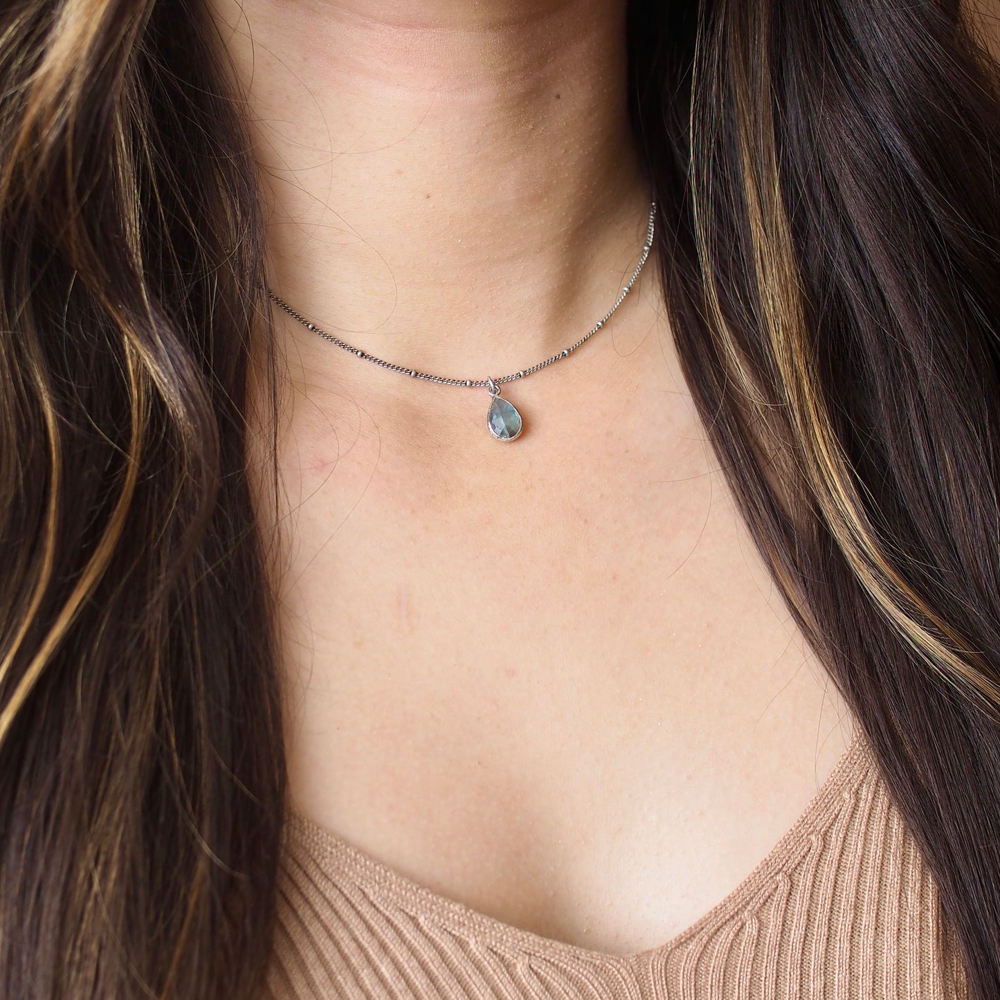 Mini labradorite teardrop choker set on a dusty silver gunmetal choker, shown on a model for scale