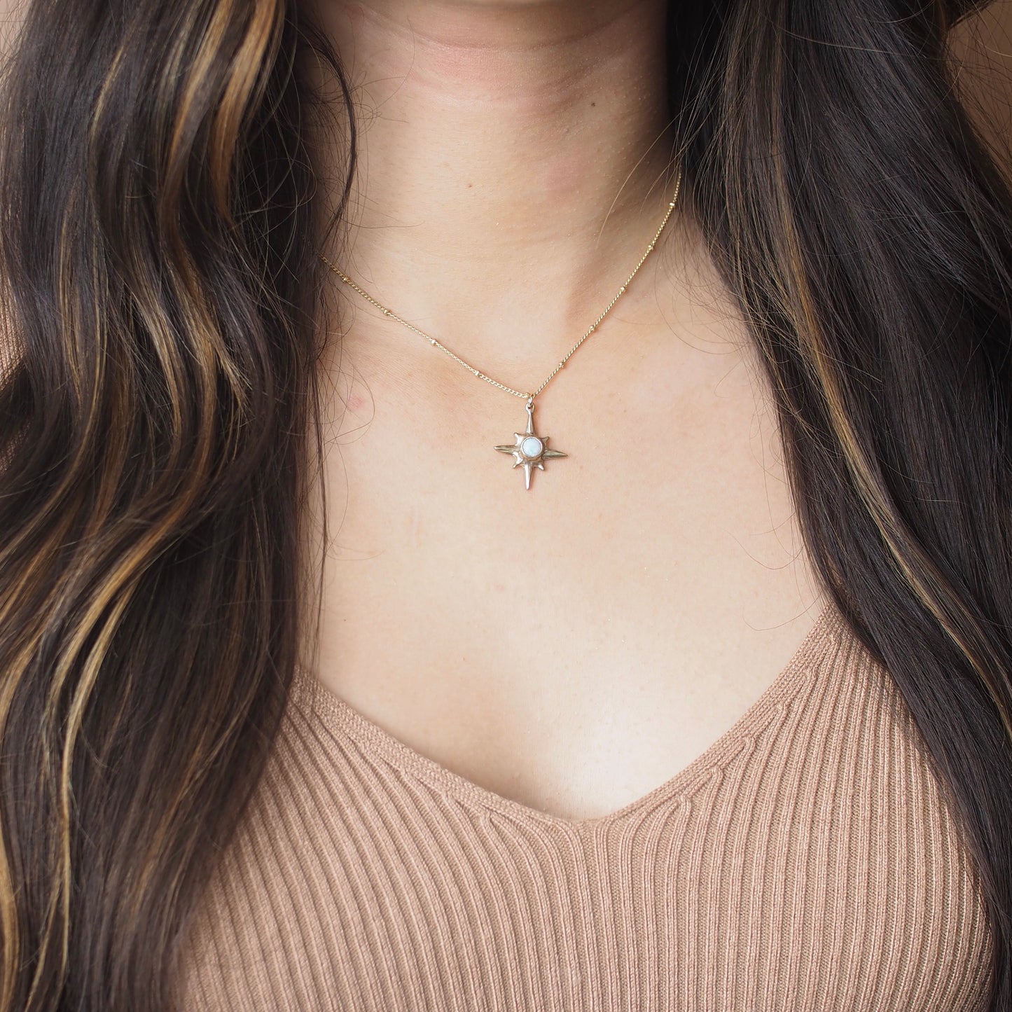 Shiny gold Iron Oxide North Star Polaris Necklace on body