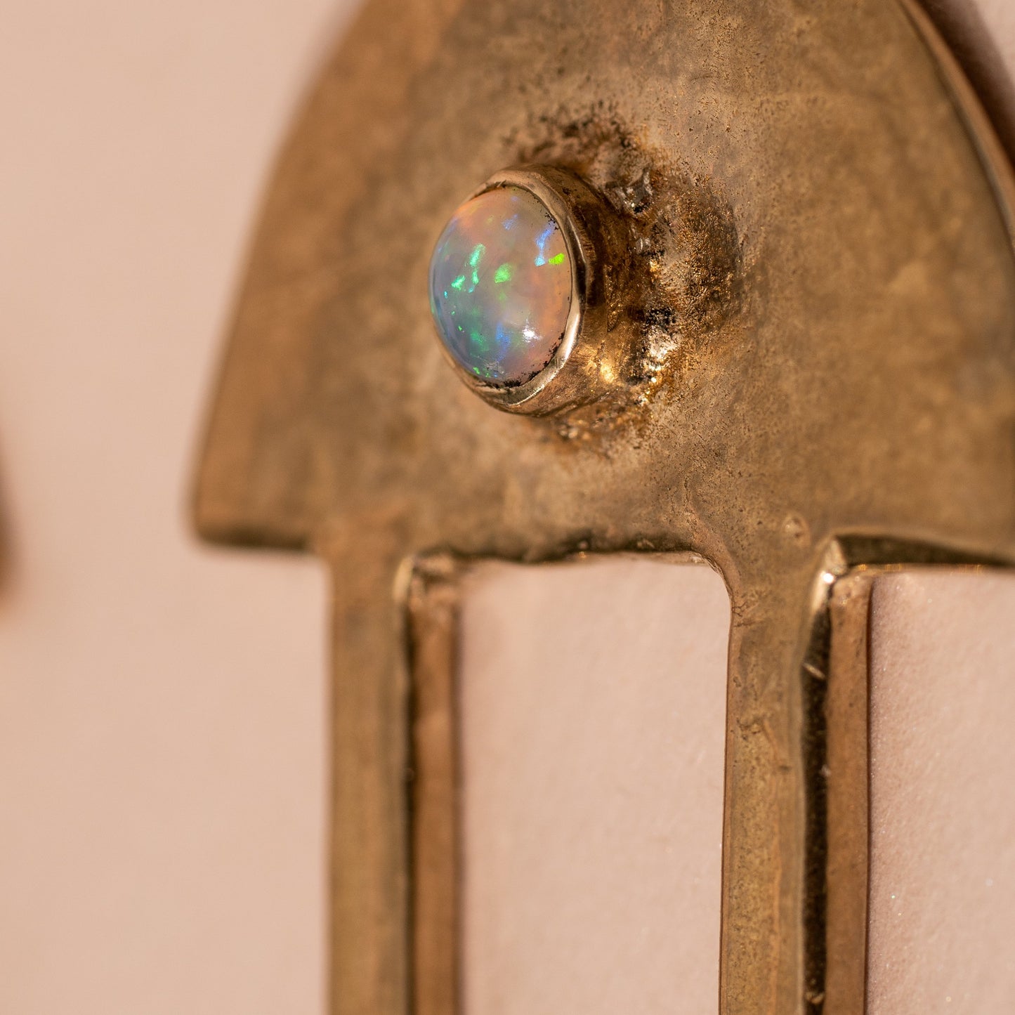 Close up of a brass, gold tone Iron Oxide hair stick set with a 5mm Opal stone