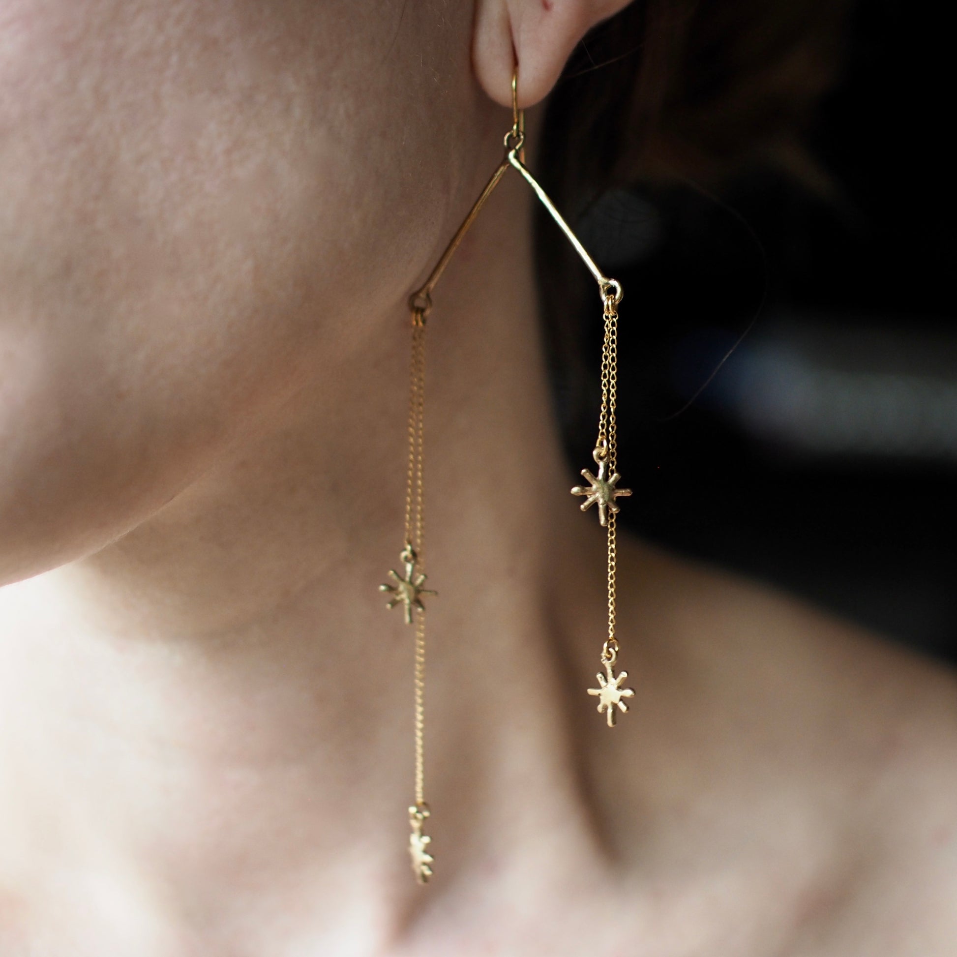 Falling star chain earrings with glitter motifs by Iron Oxide Designs on a model
