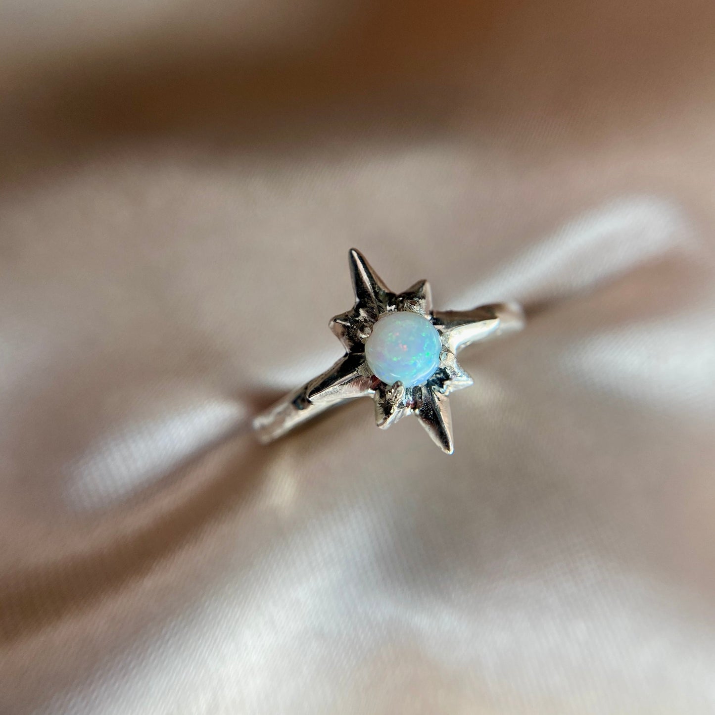 Polaris north star ring set with a tiny lab grown opal in sterling silver handmade by Iron Oxide Designs