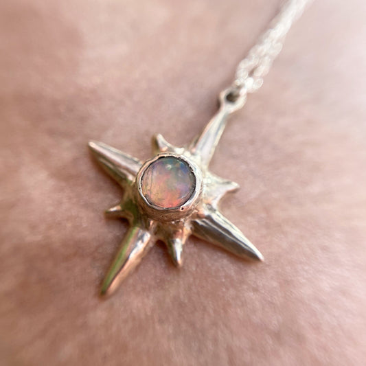 Iron Oxide Silver Polaris Choker set with a natural opal on a pink background