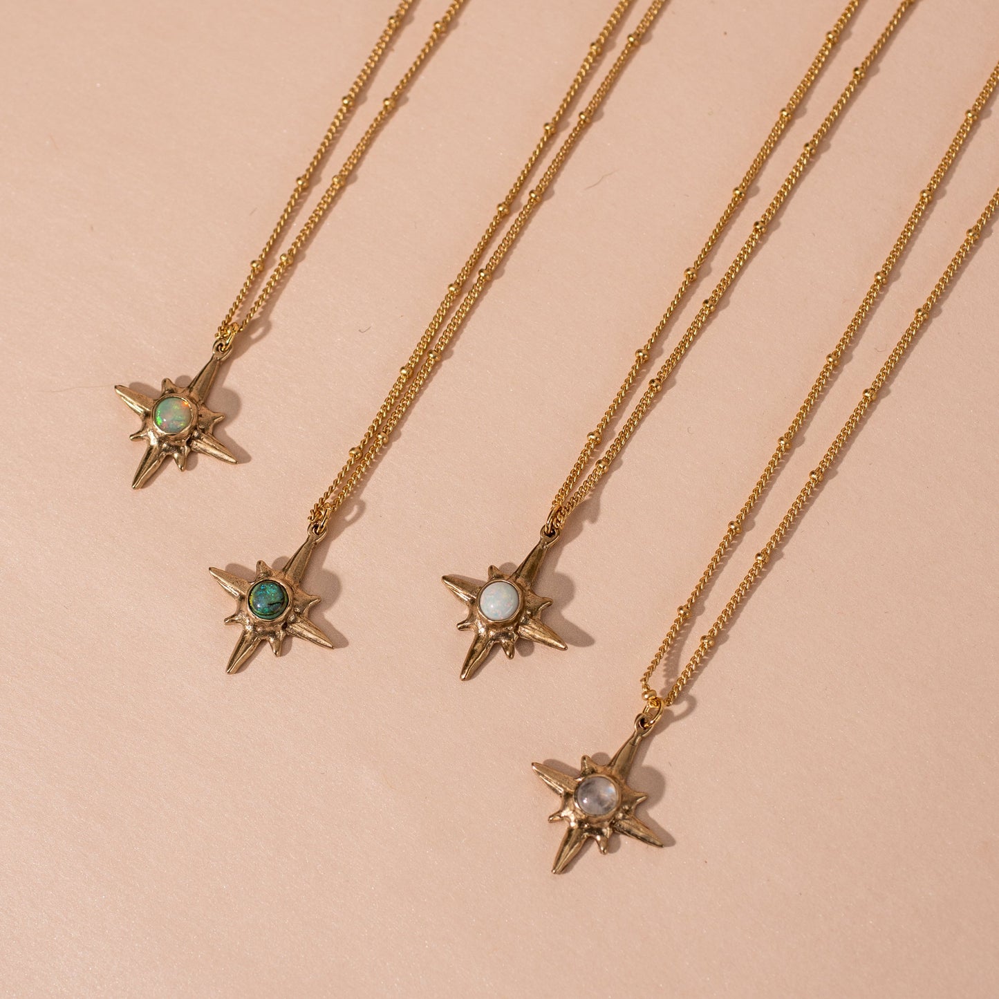 Collection of Shiny gold Iron Oxide North Star Polaris Necklaces set with gemstones