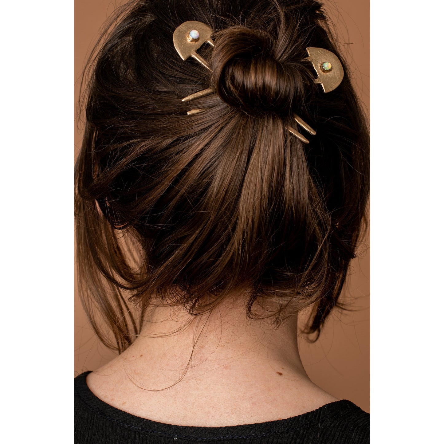 Two brass  Iron Oxide hair sticks in a messy bun